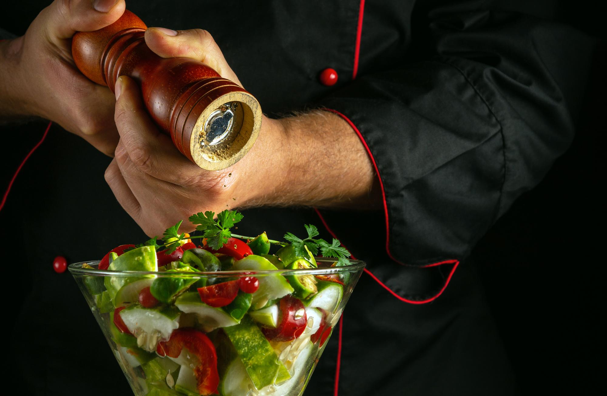 Chef hands finishing garnish on bowl